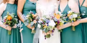 A group of women hold vibrant, colorful bouquets.